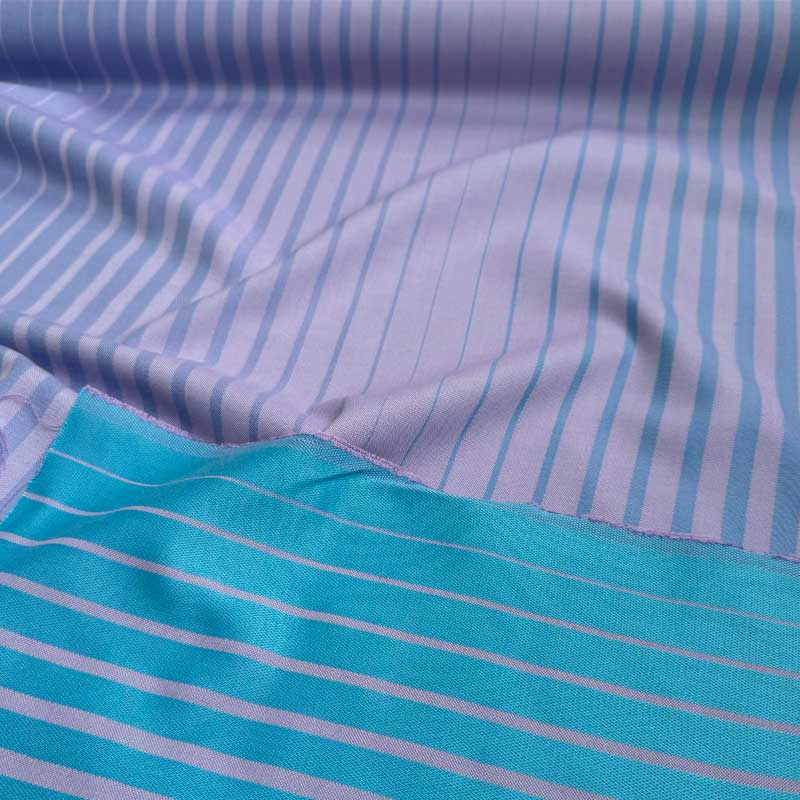 Boligtekstil fra Kvadrat med striber i lilla/blå nuancer - KreStoffer