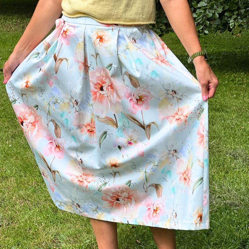 Fast stof med sommerblomster på lyseblå bund