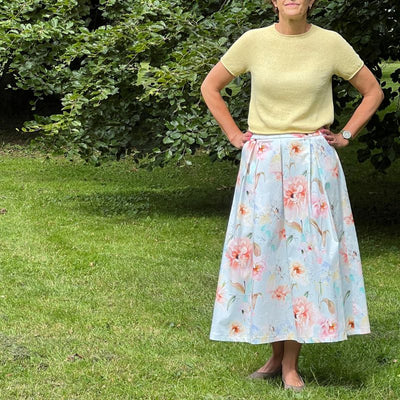 Fast stof med sommerblomster på lyseblå bund