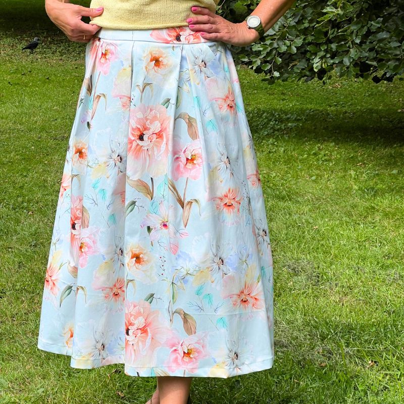 Fast stof med sommerblomster på lyseblå bund