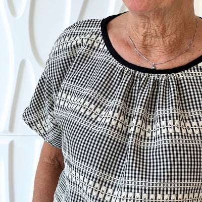 Vævet bomuld med tern og broderi i sort