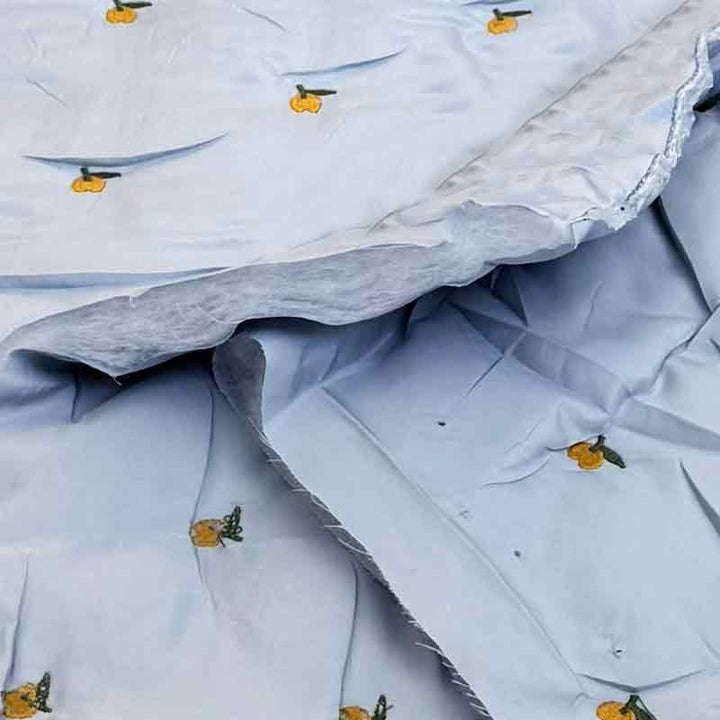 Lyseblå quilt med broderet frugt