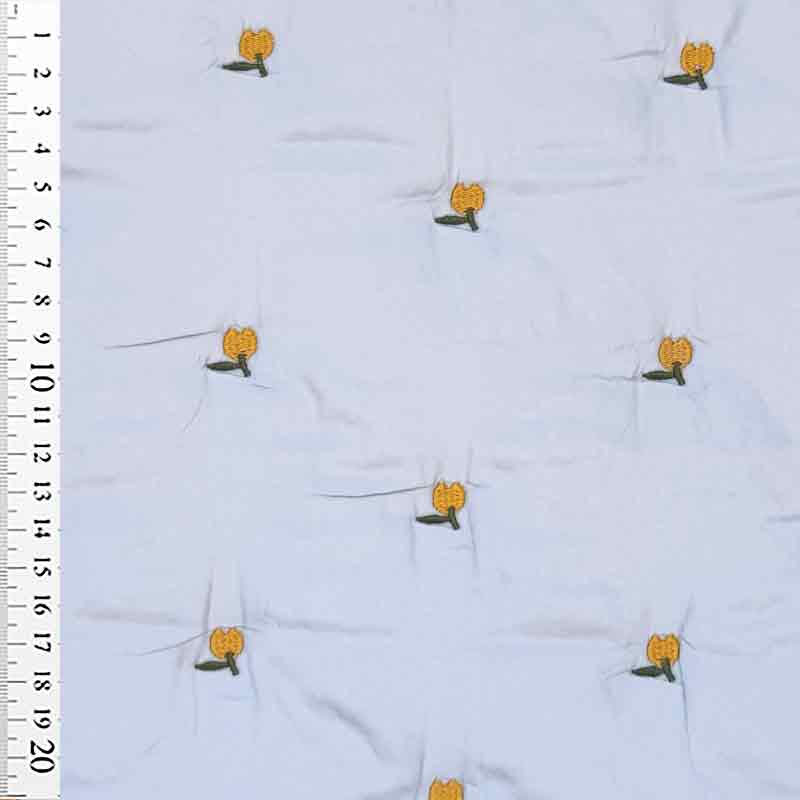 Lyseblå quilt med broderet frugt