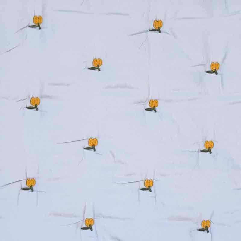 Lyseblå quilt med broderet frugt