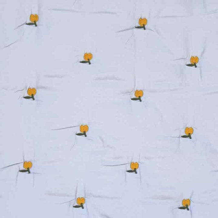 Lyseblå quilt med broderet frugt