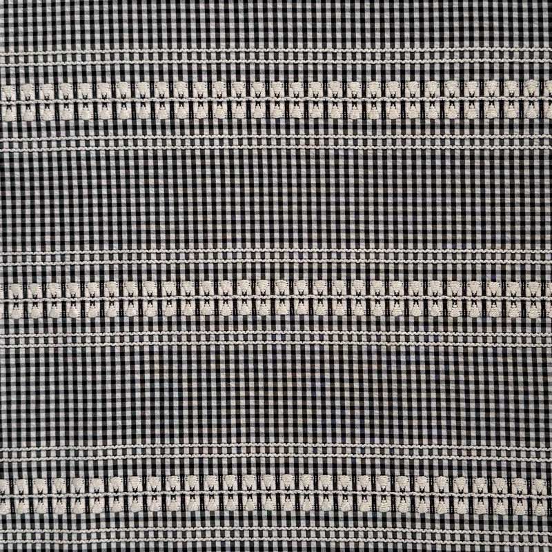 Vævet bomuld med tern og broderi i sort